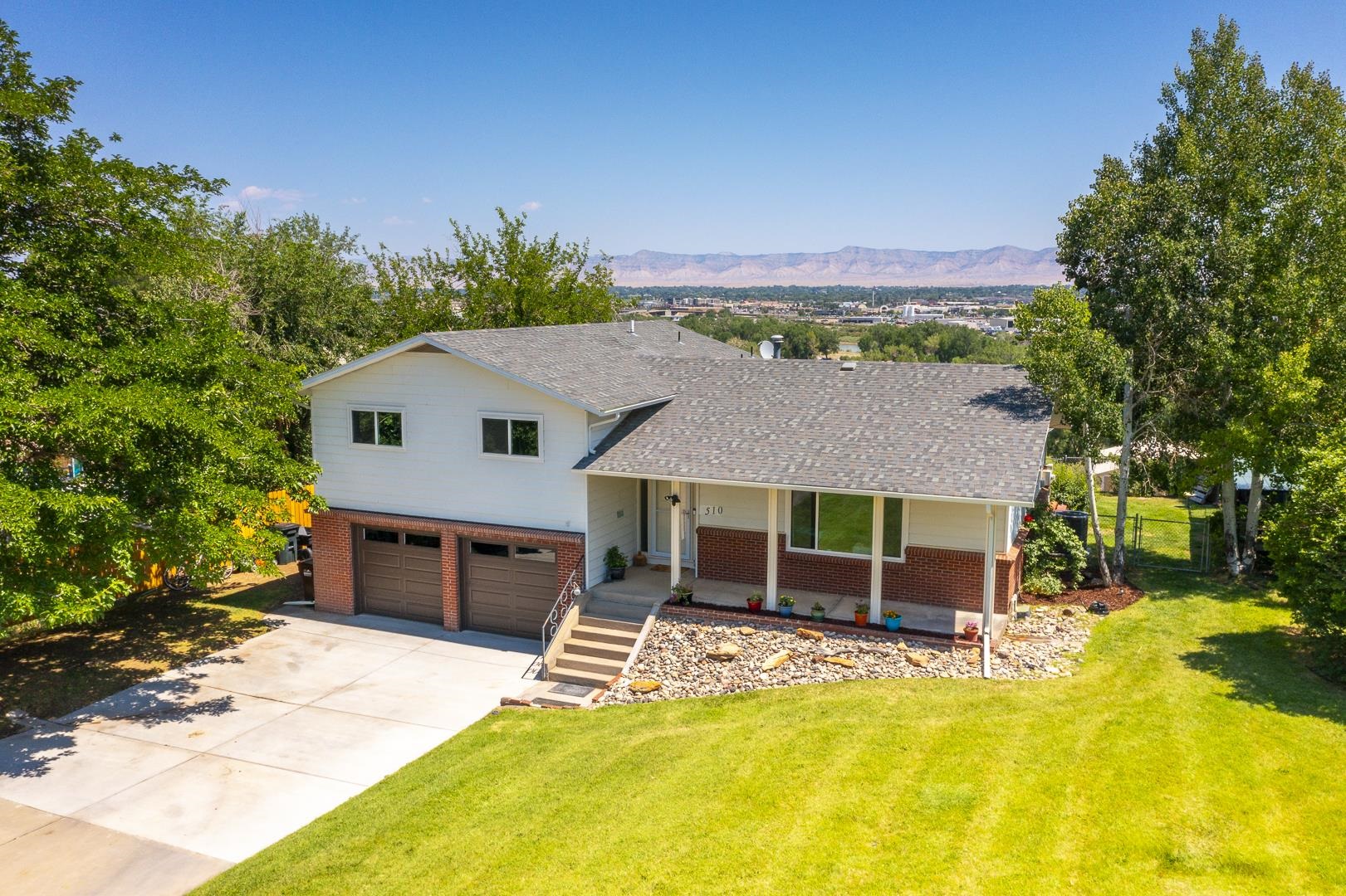 Nestled within the breathtaking landscapes of The Redlands, this home offers beautiful unobstructed views from your back deck of the majestic Bookcliffs, Mt. Garfield, connected lakes and the city lights of Grand Junction. This home features solid surface countertops, center island, gas range, and 2 pantries. Many upgrades include:  All New E-Rated Windows (2023), New Garage Doors (2024), ALL new Kitchen Appliances (2022), Entire Attic is R-38 insulated (2023). The lower level offers endless possibilities such as family room, home office with its on entry, rental income, in-law or teenage suite with 3/4 bathroom. Situated on a generous lot .66 acres, irrigation, and NO HOA!  Lots of storage and a large shed plus ample parking.  Chickens are welcome too!