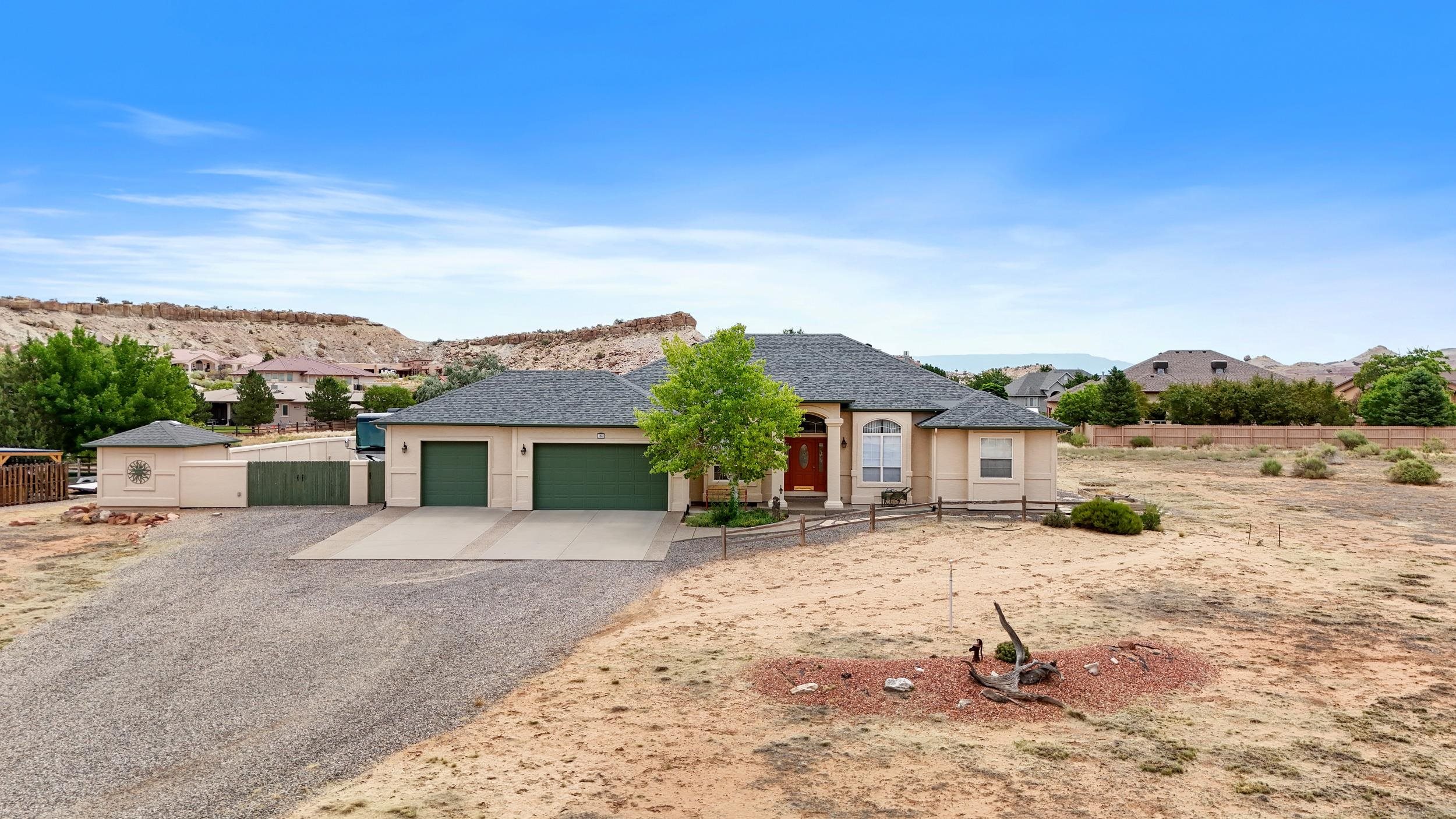 Sitting at the base of the Colorado National Monument, this beautiful and well cared for home is waiting for you! It offers 3 bedrooms, 2 bathrooms, a 3 car garage with a work bench, a storage shed, PLUS a large 28'x30' shop. Not to mention the views! This home has ample living space inside and out! The shop offers heating and cooling, 220 power, an epoxy coated floor, workspace and a large air compressor. Outside the shop is RV parking along with electrical hookup and a dump station. Inside, the home is bright and clean. The pantry in the kitchen is nice and large and there is plenty of storage space throughout the home. This home is located close to walking and hiking trails, sits on a quiet cul-de-sac and is minutes from the Lunch Loops. Don't miss out on this beautiful home in a prime location.