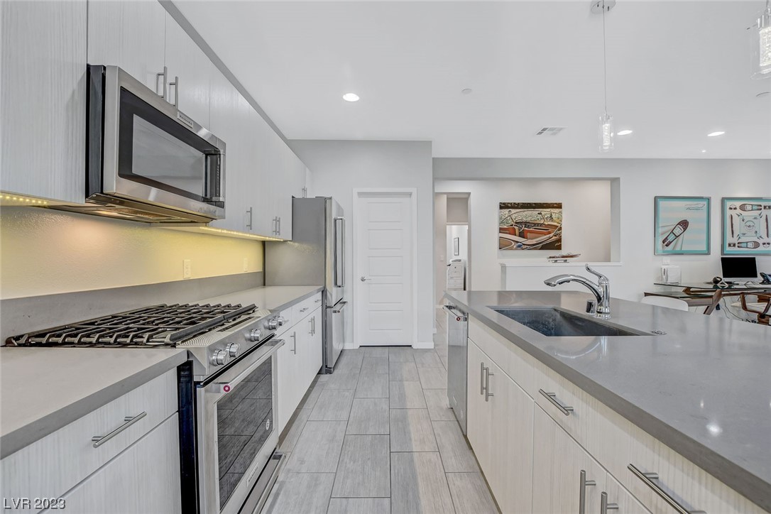 The kitchen offers ample storage, walk-in pantry, island, stainless steel appliances and quartz countertops.