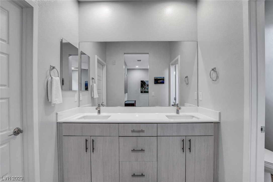 Primary bathroom features dual sinks and walk-in shower.