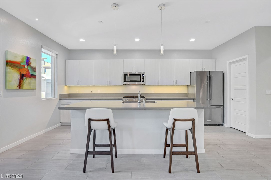 The kitchen offers ample storage, walk-in pantry, island, stainless steel appliances and quartz countertops.