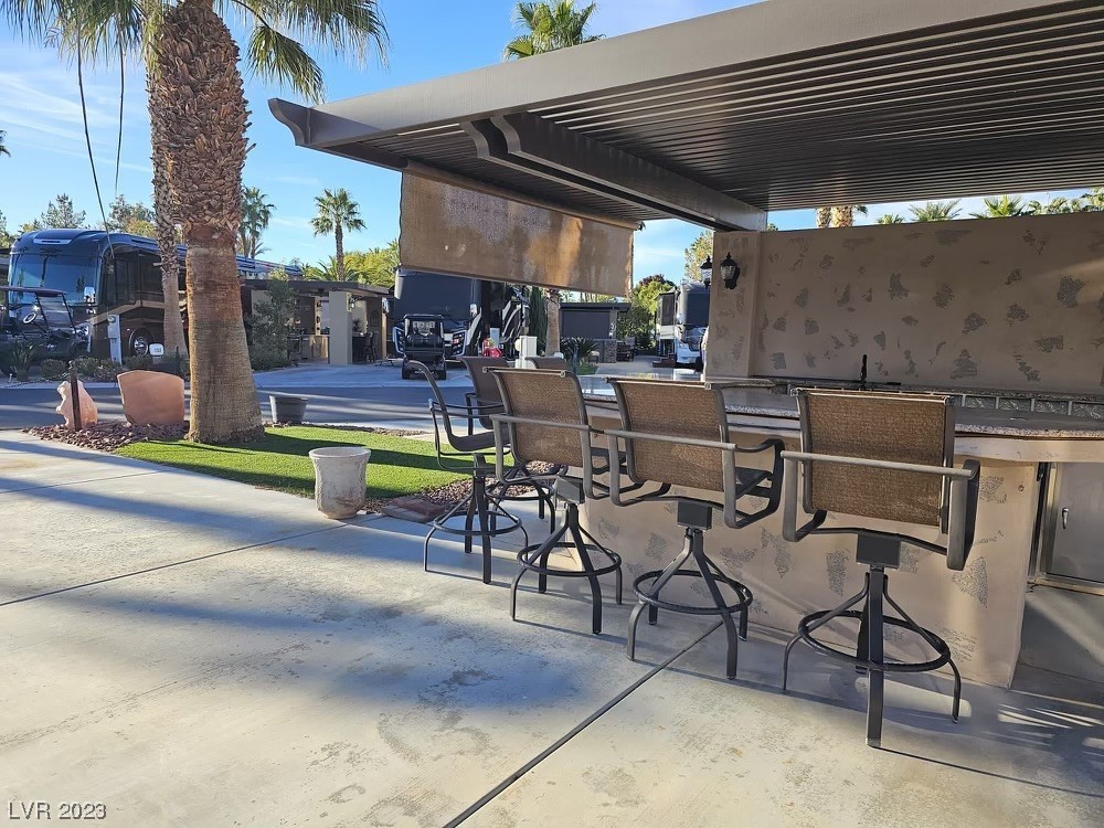 Located in the guard gated Las Vegas Motorcoach Resort, this amazing site is right near the main clubhouse!    This loaded site located near all the resort amenities features a hard roof structure, full kitchen, bar seating area, fireplace, storage area, and much more!   Priced to go quick!