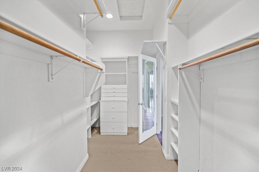 The primary closet features custom cabinetry and drawers