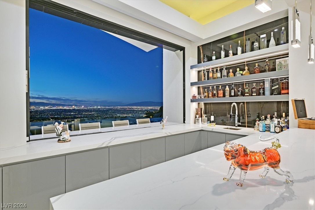 Great room fully equipped wet bar with pocket windows that open to the city view and outdoor service area.