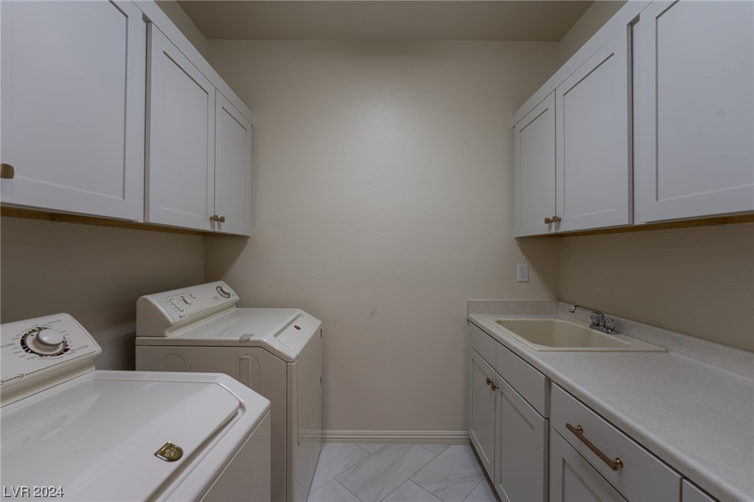 Separate laundry room with custom cabinetry, sink and washer/dryer included.