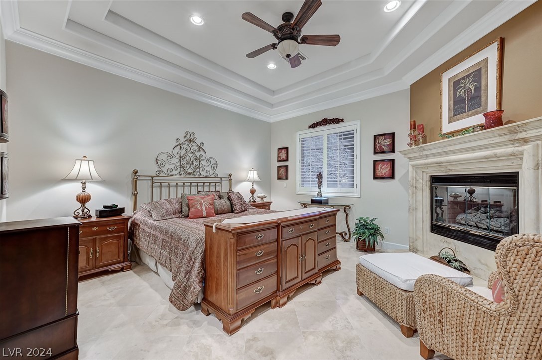 The primary bedroom with a soffit ceiling offers an elegant retreat. Travertine floors throughout.