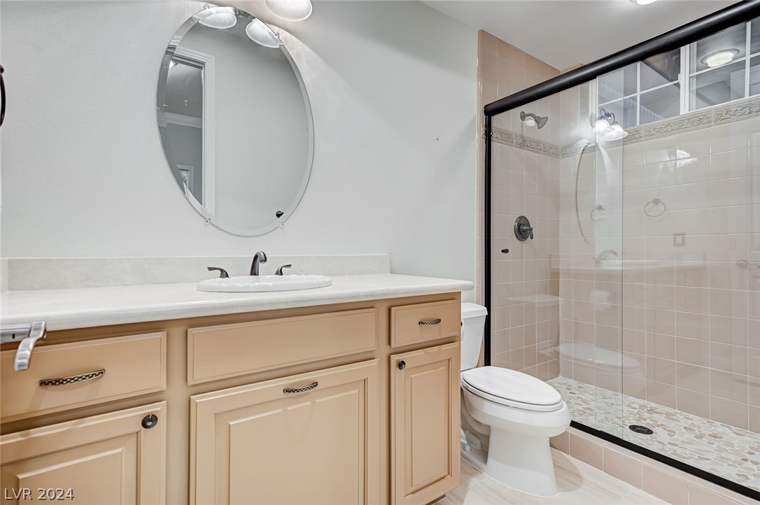 The second bedroom's private bath has been remodeled with new sinks, cabinets, and shower doors.