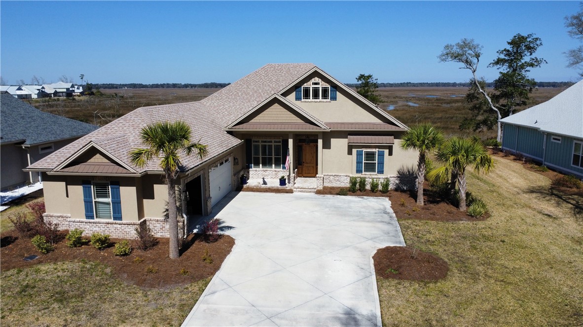 Better than new on the marsh! Step into this coastal cottage style home with great views of the marsh behind the home as well as the privacy the marsh affords. This home features two living areas and a dining room. All living areas are tile with crown molding. The large kitchen has stainless steel appliances, quartz counter tops, island, walk-in pantry and custom wood cabinets. The over-sized master suite features a separate tile shower, large vessel tub, huge walk-in-closet, and dual vanities. The three car garage is finished in T1-11 wood paneling on the walls. The large outdoor living space and screened back porch with hot tub offers a great place to relax or entertain guests while enjoying panoramic marsh views.  Better than new because of the water softener system, plantation shutters and custom blinds. The HOA includes lawn care, irrigation, and access to the pool, tennis courts, and fitness center.