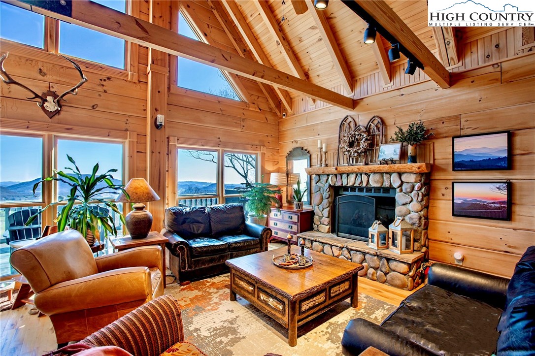 PRISTINE MOUNTAINTOP RETREAT sitting at 4,000’+ elevation on 2 AC with four levels of living space featuring stunning long range mountain views and end-of-road privacy in a beautifully landscaped setting with pond! Grand open floor plan with vaulted T&G ceilings, hardwood floors, stone fireplace , and an enormous wall of windows to enjoy the expansive, ever changing views. Kitchen designed with custom Alder cabinetry, farmhouse sink & accented with granite counters is great for entertaining. Main floor boasts bedroom with designer bath, a study or flex room, and the sprawling great room with fireplace for curling up on chilly nights. Top floor Primary Suite offers a lovely sanctuary with cozy view of the loft seating area. Lower level features family room, wet bar, 2nd Master Suite & laundry area. Finished basement provides elegant entertainment space and access to the 2 car garage. Outside, enjoy relaxing and taking in nature's glory while relishing the morning sunrise views on 3 levels of spacious decks, both open and covered. Log home infrastructure includes metal roof, stone accent walls, and lots of storage space - high quality custom features abound in this home. Just minutes to vibrant downtown West Jefferson's dining, galleries, breweries and entertainment as well as Mt. Jefferson State Park, New River access and all of you outdoor activities. This home exemplifies the best of quality, privacy and convenience - truly a mountain top gem!