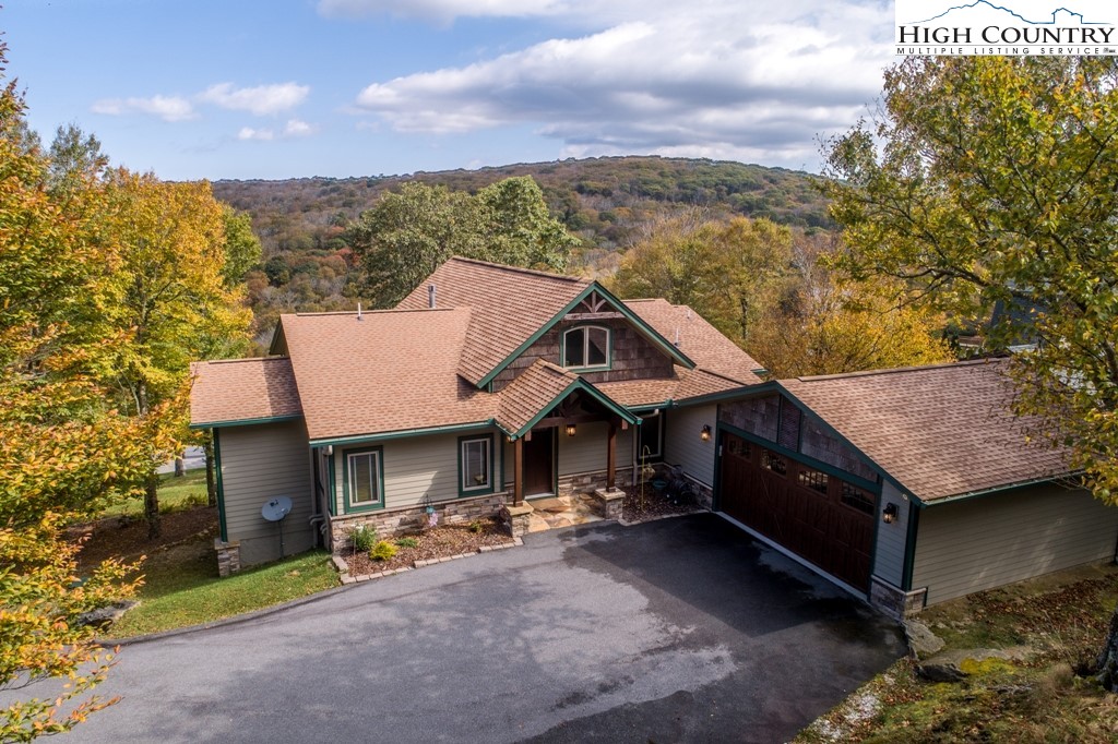 Located in the heart of Beech Mountain, this stunning mountain retreat at 371 Woodland Way offers the perfect combination of luxury and tranquility. Situated on a spacious lot with breathtaking views, this custom-built home boasts impeccable craftsmanship and attention to detail throughout. Upon entering, you are greeted by a grand foyer that leads to the expansive great room with vaulted ceilings, exposed beams, and a floor-to-ceiling stone fireplace. The open-concept floor plan seamlessly flows into the gourmet kitchen, complete with high-end stainless steel appliances, custom cabinetry, and granite countertops. The dining area features a large picture window framing the picturesque mountain scenery. The main level also includes a luxurious primary suite with a spa-like ensuite bath, as well as an additional guest bedroom and a full bath. The lower level offers a second living area, a separate theater room, and access to the outdoor patio, perfect for entertaining guests. Two additional guest bedrooms, a spacious office, and a full bath complete the lower level. The exterior living spaces are just as impressive, with multiple decks and patios perfect for enjoying the serene mountain surroundings. The landscaped yard is ideal for outdoor activities and offers plenty of space for gardening or outdoor gatherings. Conveniently located near the ski slopes, hiking trails, and other amenities, this home is the perfect mountain getaway for outdoor enthusiasts. Whether looking for a full-time residence or a vacation home, 371 Woodland Way offers the ultimate mountain living experience. Don't miss the opportunity to own this exquisite property in the desirable Beech Mountain community, minutes to downtown Banner Elk. Schedule your private showing today! Note: There is a discrepancy between the tax office and professional measurements.