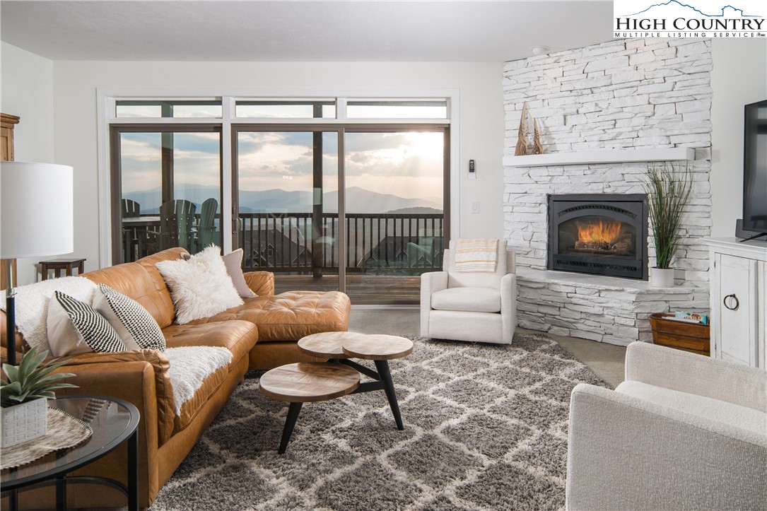 Rare, FULLY FURNISHED, Turnkey, Condo w/ breathtaking views & rental history. This stunning 2BR/2BA condo offers the epitome of luxury mountain living, boasting jaw dropping panoramic views stretching 180º from the southern to northern horizons. Step inside to discover a meticulously curated space featuring all-new furniture in 2022, thoughtfully arranged to maximize comfort and style. This home is offered fully furnished, ensuring a seamless transition to your mountain oasis. The primary ensuite bedroom is a true haven, featuring a plush king bed, a walk-in tile shower, and a sumptuous soaking tub perfectly positioned to capture the southern mountain vistas. With dual vanity and granite countertops, this spa-like retreat offers both elegance and convenience. Cozy up by the gas stone fireplace in the spacious living area, where floor-to-ceiling windows frame the awe-inspiring long-range views. The open-concept kitchen dazzles with granite countertops and modern appliances, inviting culinary adventures with a backdrop of mountain grandeur. Recent upgrades include a BRAND-NEW HVAC April '24 w/ wifi enabled thermostat, ensuring year-round comfort and efficiency. Indulge in relaxation on your 300 sq. ft. covered deck, complete with brand new hot tub (Oct. '22) – one of the rare units in the complex that meets deck requirements for this luxurious amenity. Additional features include an in-unit washer and dryer, and flat-screen smart TVs in every room for entertainment at your fingertips. Positioned in one of the best locations within the complex, this corner unit offers unparalleled views, facing in the opposite direction of the Sugar Top Resort. Plus, enjoy the convenient 0.3-mile walk to nearby Sugar Mountain Ski Slopes. Don't miss the opportunity to experience mountain living at its finest – schedule your showing today and prepare to be captivated by the charm and beauty of The Reserve at Sugar Mountain!