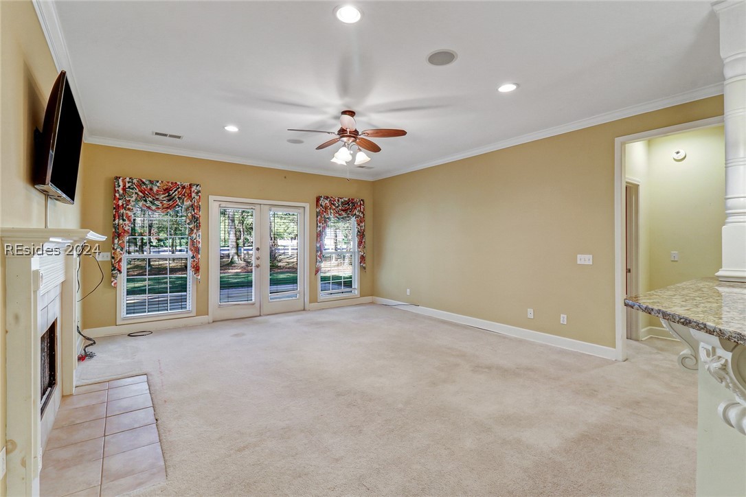  living room featuring french doors, light carpet, crown molding, and ceiling fan