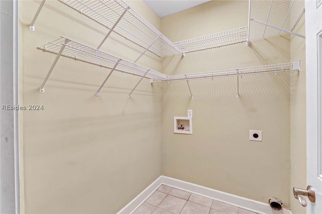 Laundry room with washer hookup, electric dryer hookup, and light tile floors