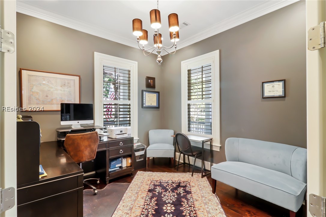 Office with crown molding, a notable chandelier, dark wood-type flooring, and a wealth of natural light