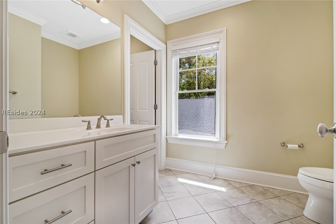 Bathroom featuring ornamental molding, tile floors, toilet, and oversized vanity