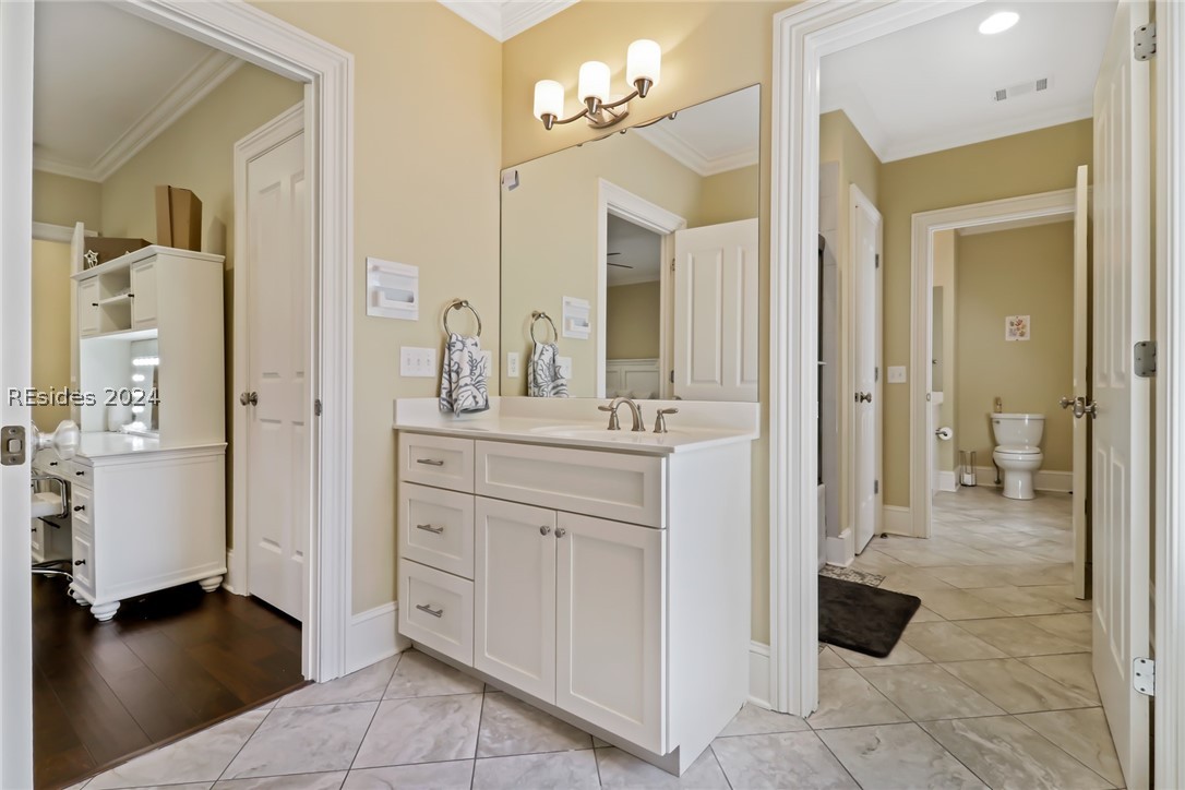 Bathroom 4 with vanity, tile floors, and crown molding