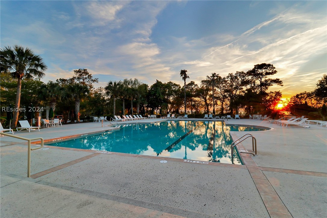 Community Pool at dusk featuring a patio