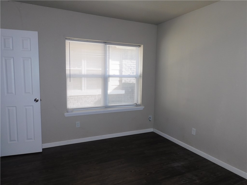 2321 NW 12th Street, #A, Oklahoma City, OK 73107 spare room with dark wood-type flooring