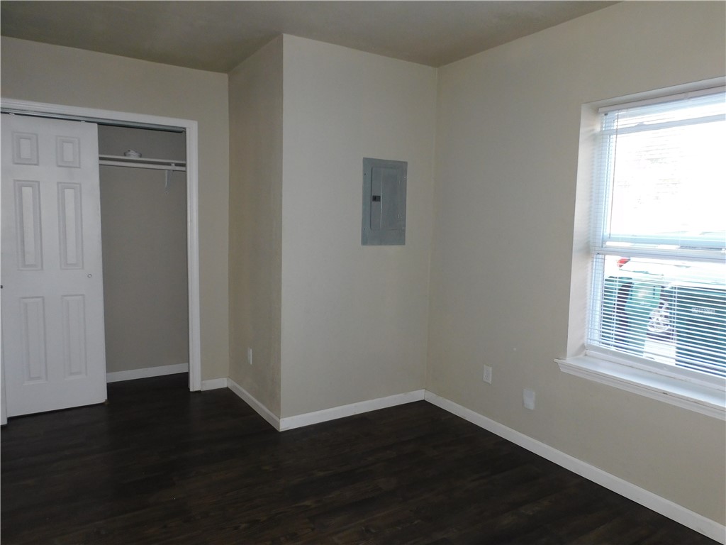 2321 NW 12th Street, #A, Oklahoma City, OK 73107 unfurnished bedroom with a closet and dark wood-type flooring