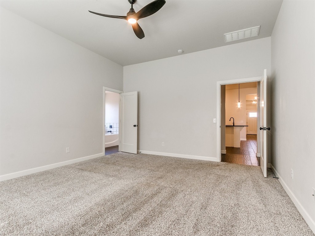6604 NW 155th Street, Edmond, OK 73013 unfurnished bedroom featuring light carpet and ceiling fan