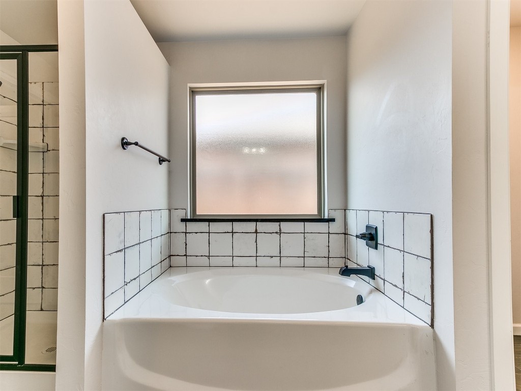 6604 NW 155th Street, Edmond, OK 73013 bathroom featuring shower with separate bathtub