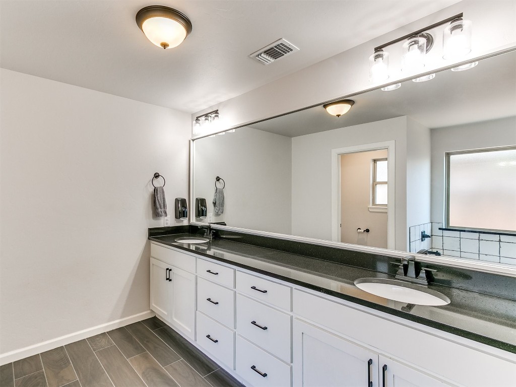6604 NW 155th Street, Edmond, OK 73013 bathroom featuring wood-type flooring and double vanity