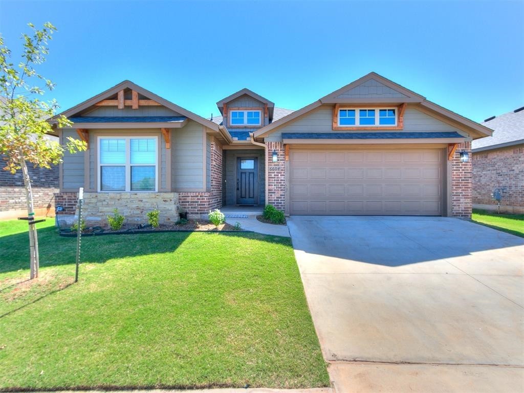 6604 NW 155th Street, Edmond, OK 73013 craftsman inspired home with a front lawn and a garage