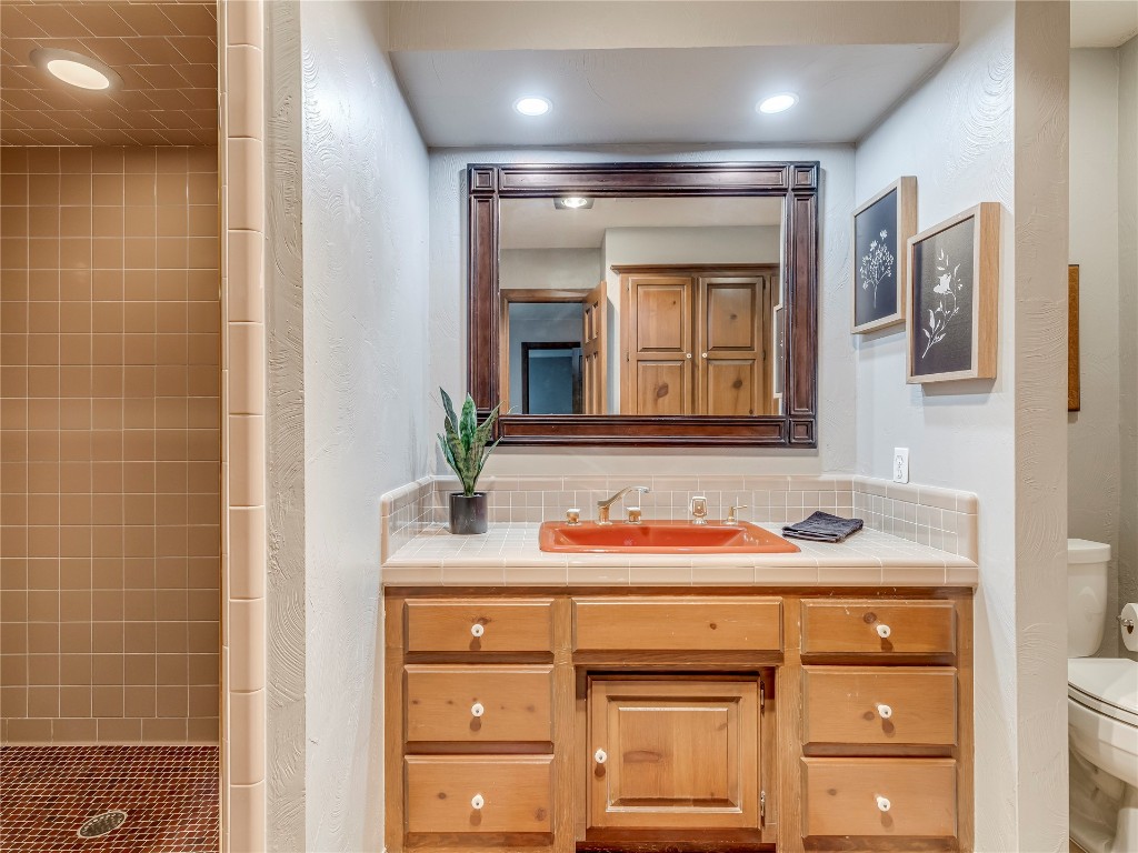 11425 Robinwood Lane, Oklahoma City, OK 73131 bathroom featuring backsplash, toilet, vanity, and tiled shower