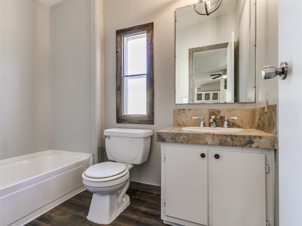 12677 NE 63rd Street, Spencer, OK 73084 bathroom featuring hardwood / wood-style floors, ceiling fan, vanity, and toilet