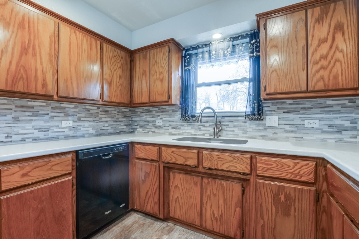 1310 Choctaw Trail, Blanchard, OK 73010 kitchen featuring sink, black dishwasher, tasteful backsplash, and light hardwood / wood-style flooring
