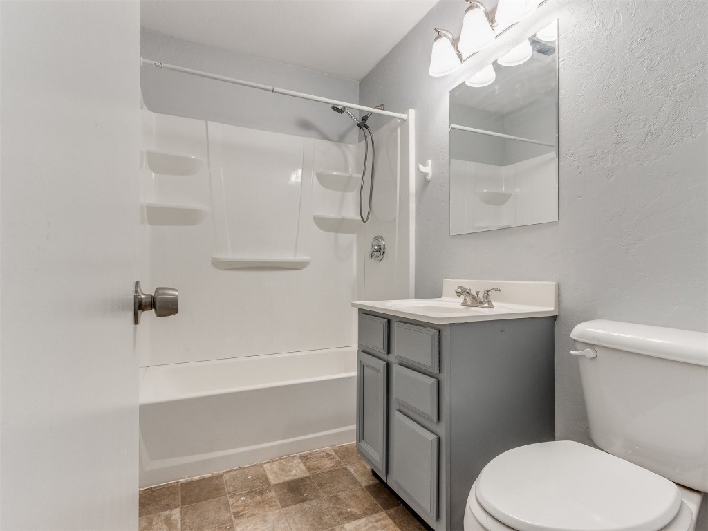 9312 NE 13th Street, Midwest City, OK 73130 full bathroom with vanity, toilet, tile flooring, and washtub / shower combination
