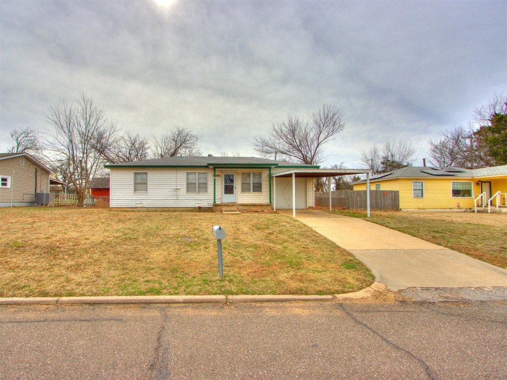 9312 NE 13th Street, Midwest City, OK 73130 single story home with a carport and a front lawn