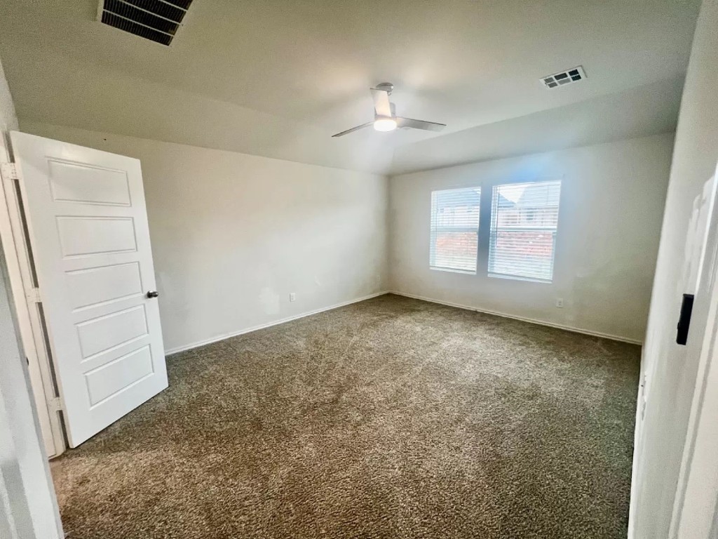 11217 SW 33rd Terrace, Yukon, OK 73099 empty room with dark colored carpet and ceiling fan