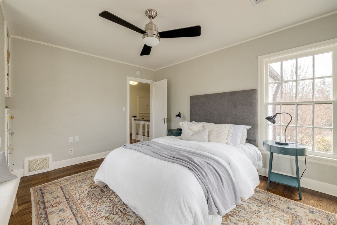 817 NW 40th Street, Oklahoma City, OK 73118 bedroom with dark hardwood / wood-style floors, multiple windows, and ceiling fan
