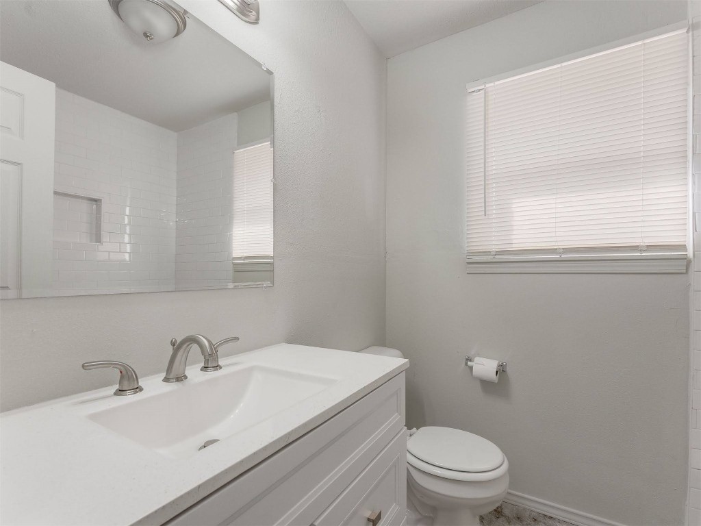 209 NW 80th Street, Oklahoma City, OK 73114 bathroom featuring a wealth of natural light, vanity, and toilet
