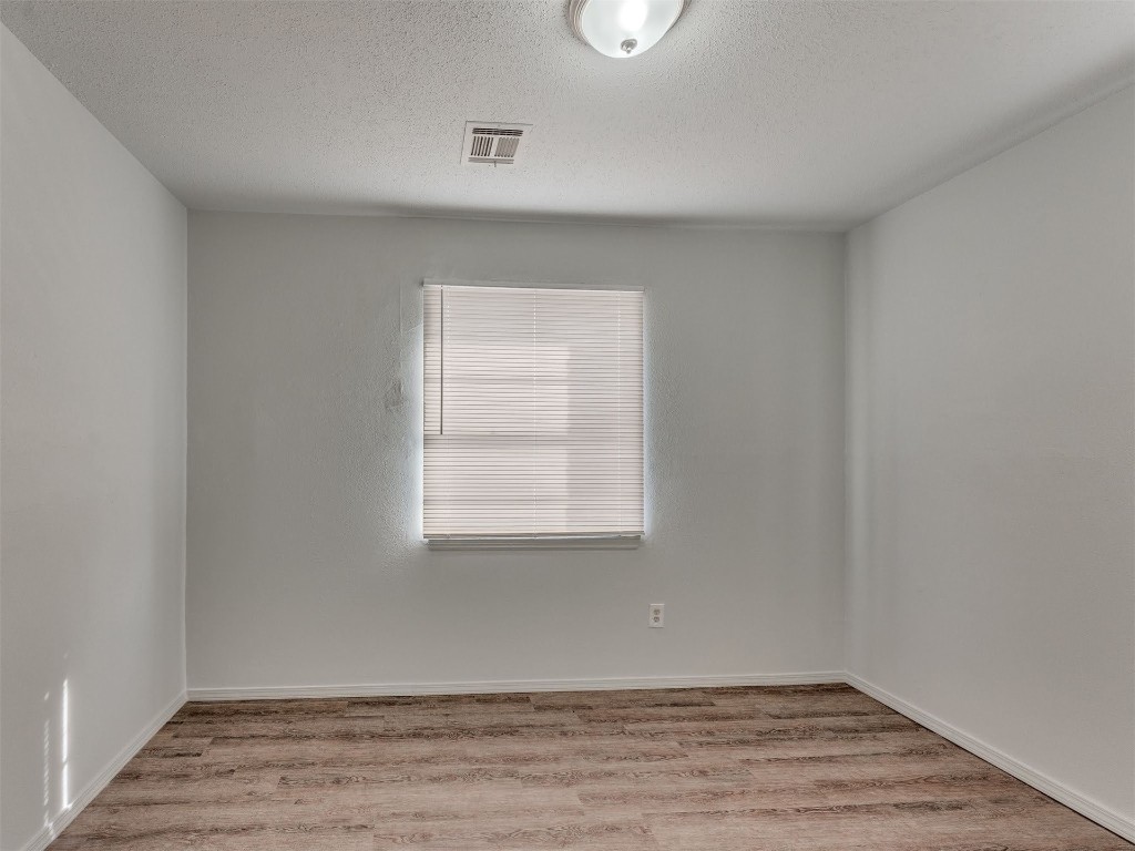 209 NW 80th Street, Oklahoma City, OK 73114 unfurnished room featuring light hardwood / wood-style flooring and a textured ceiling