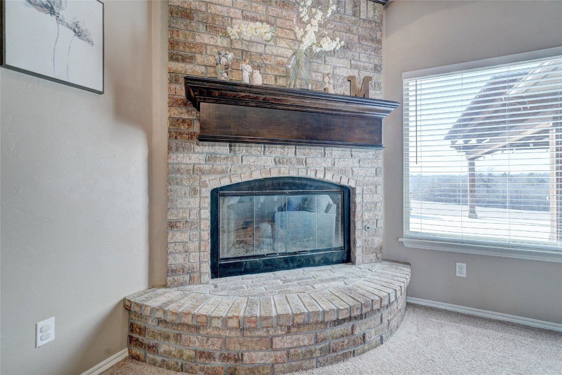 145 Oakridge Drive, Choctaw, OK 73020 room details with a brick fireplace and light carpet