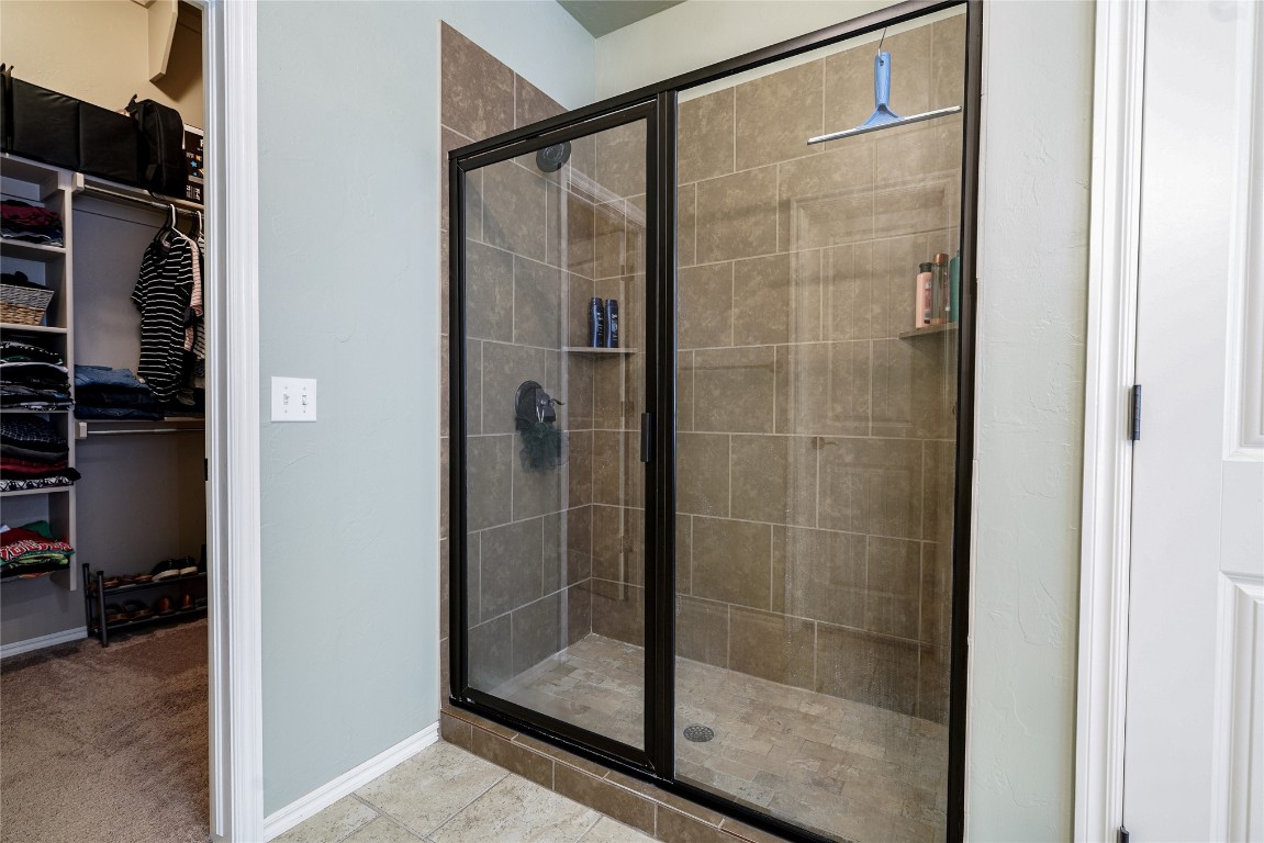 145 Oakridge Drive, Choctaw, OK 73020 bathroom featuring a shower with shower door and tile flooring