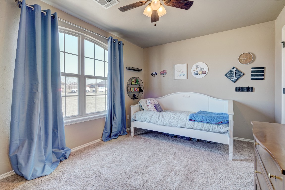145 Oakridge Drive, Choctaw, OK 73020 bedroom with ceiling fan and light colored carpet