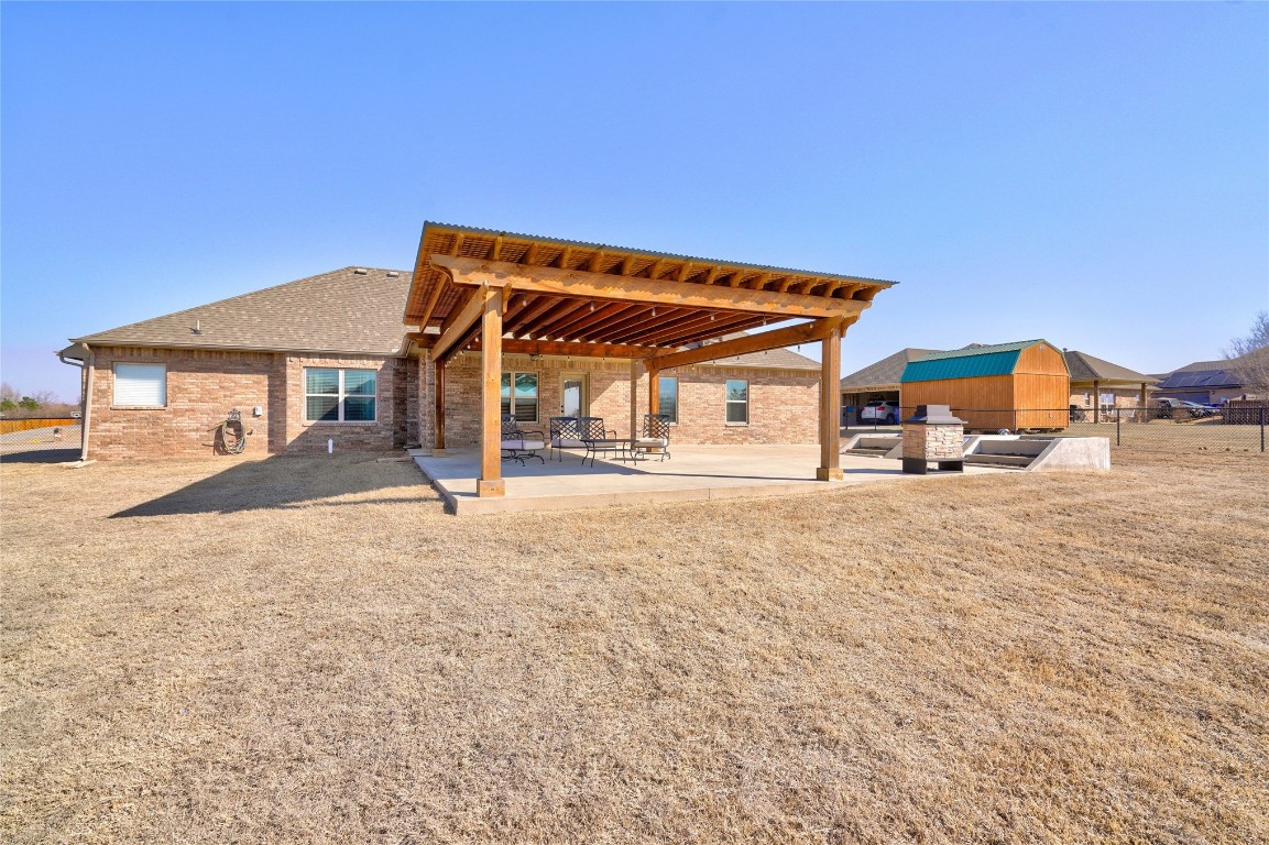 145 Oakridge Drive, Choctaw, OK 73020 back of property featuring a lawn, a pergola, and a patio