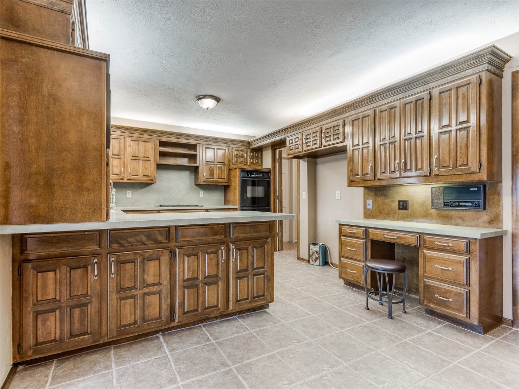 10717 Woodridden, Oklahoma City, OK 73170 kitchen with a kitchen bar and light tile flooring