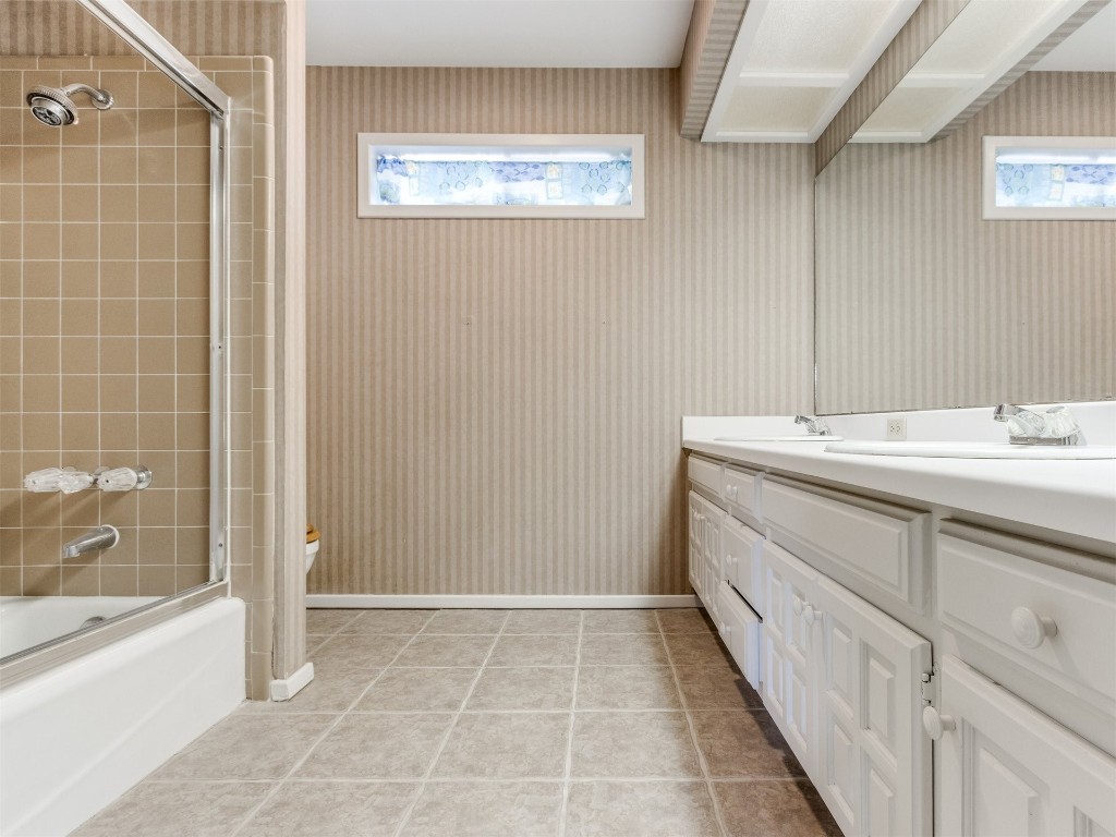 10717 Woodridden, Oklahoma City, OK 73170 bathroom with shower / bath combination with glass door, tile flooring, and vanity