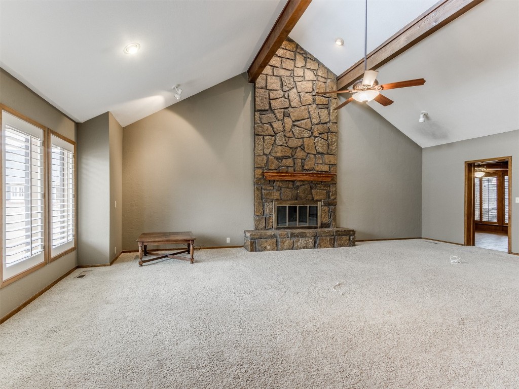 10717 Woodridden, Oklahoma City, OK 73170 unfurnished living room with light colored carpet, ceiling fan, and a stone fireplace