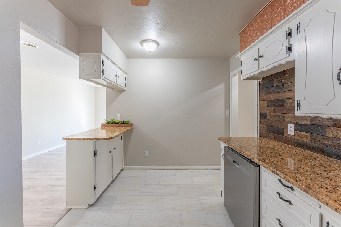 6004 S Dewey Avenue, Oklahoma City, OK 73139 kitchen with white cabinetry, light hardwood / wood-style flooring, dishwasher, and stone counters