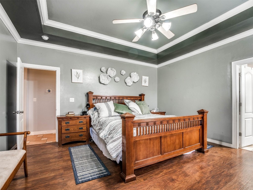 4216 Stardust Lane, Tuttle, OK 73089 bedroom with dark hardwood / wood-style floors, a raised ceiling, ceiling fan, and ornamental molding