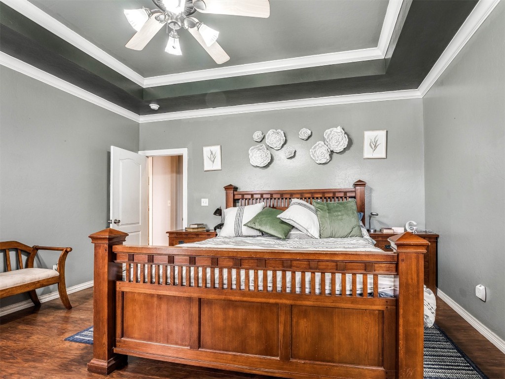 4216 Stardust Lane, Tuttle, OK 73089 bedroom featuring a raised ceiling, crown molding, ceiling fan, and dark hardwood / wood-style flooring