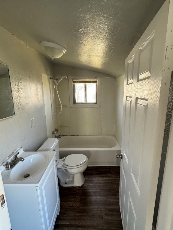 707 Oliver Street, Norman, OK 73071 full bathroom featuring hardwood / wood-style floors, bathing tub / shower combination, vanity, toilet, and vaulted ceiling