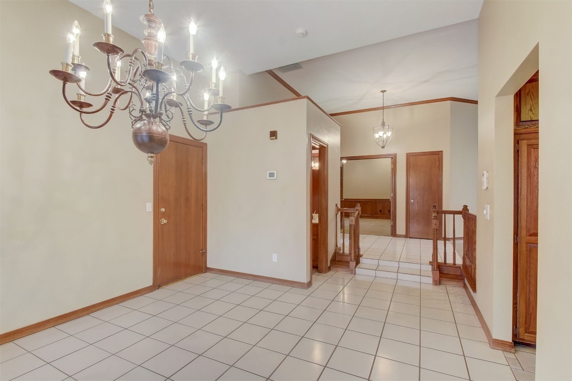 695 Kingsgate Road, Yukon, OK 73099 spare room with light tile floors and a chandelier