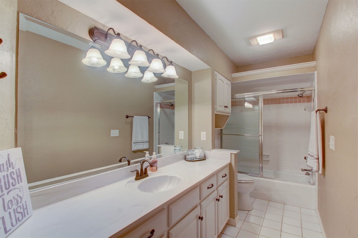 695 Kingsgate Road, Yukon, OK 73099 full bathroom featuring tile flooring, vanity, toilet, and shower / bath combination with glass door