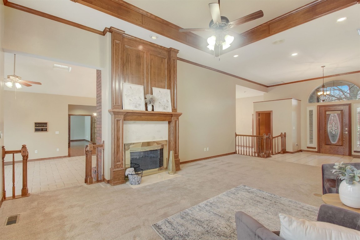 695 Kingsgate Road, Yukon, OK 73099 carpeted living room with ceiling fan, a high ceiling, and ornamental molding